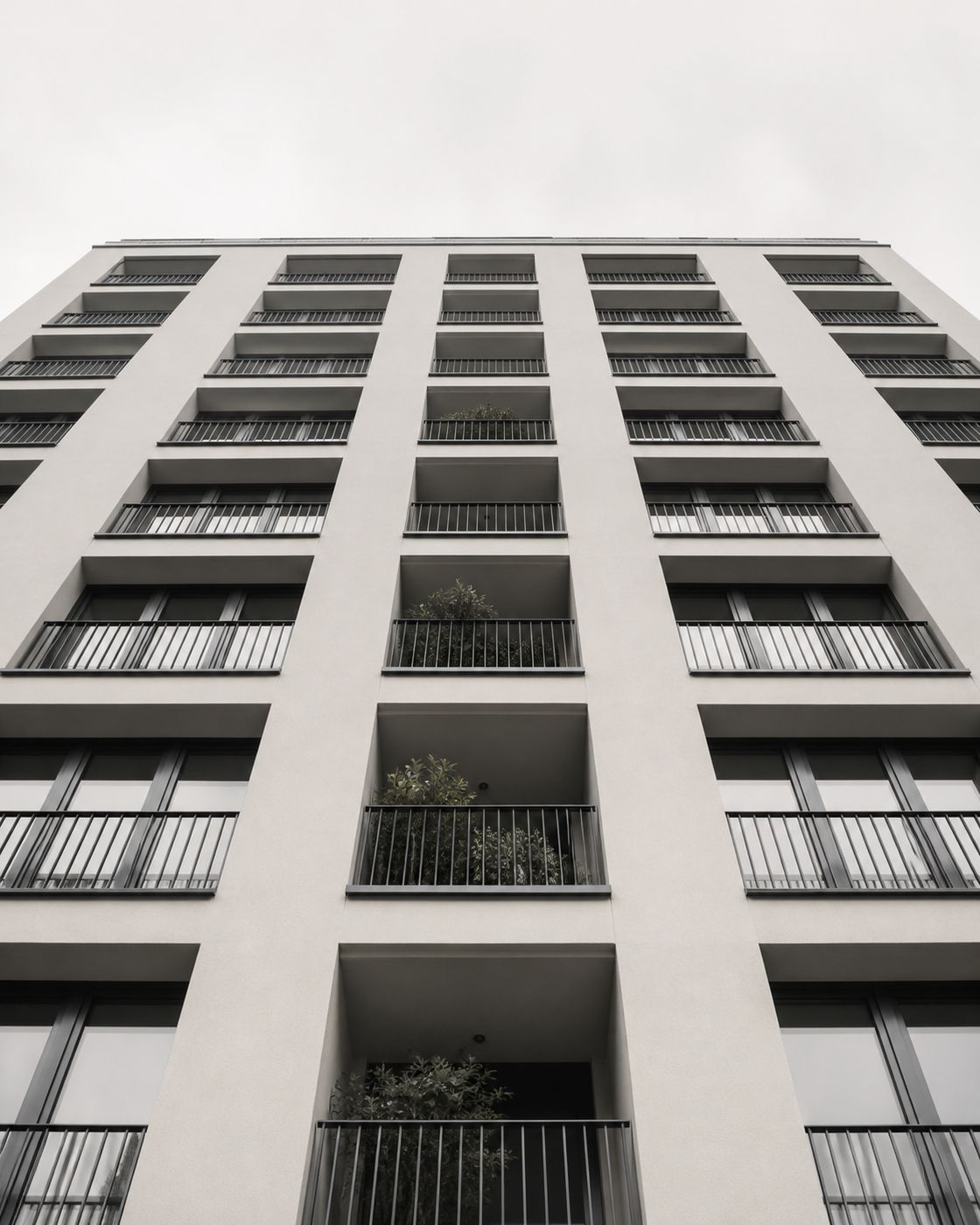 Blick von unten auf die Balkone und die gerasterte Fassade eines Wohnhauses