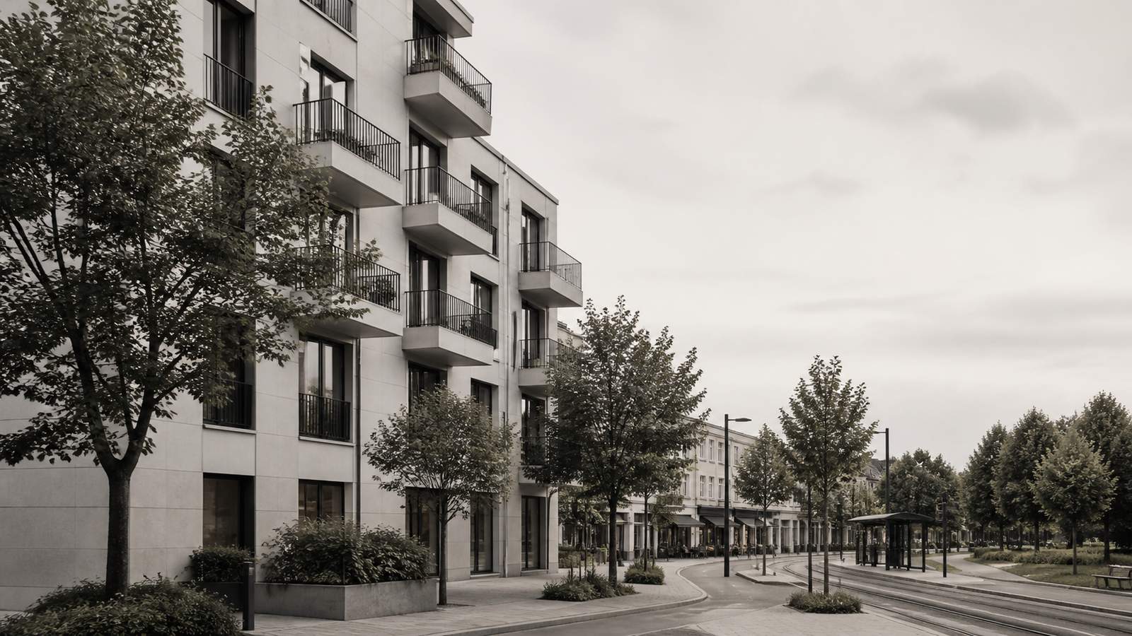 Straßenzug mit modernen Wohngebäuden und einer Straßenbahntrasse